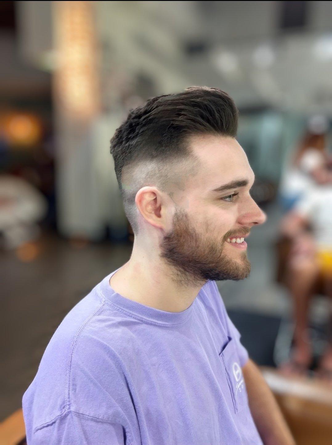 Barber refining a client's hairline with trimmers